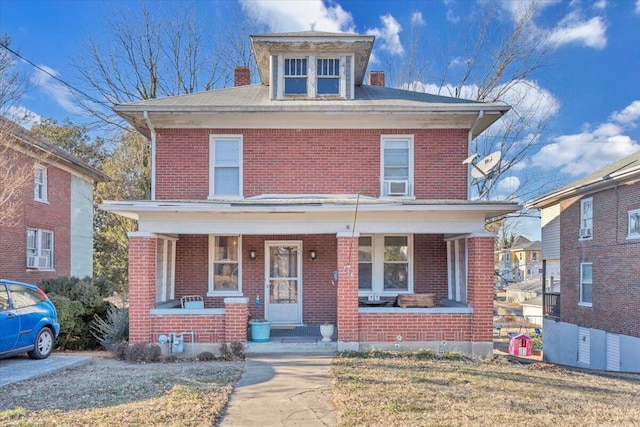 view of front of house featuring covered porch and a front lawn