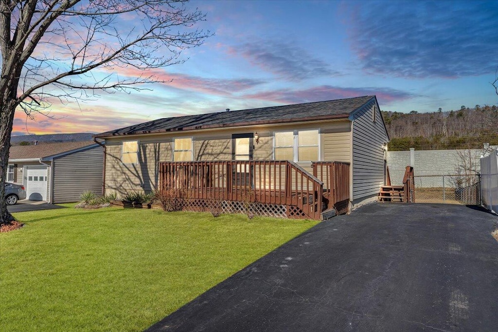 view of front of home featuring a lawn and a deck