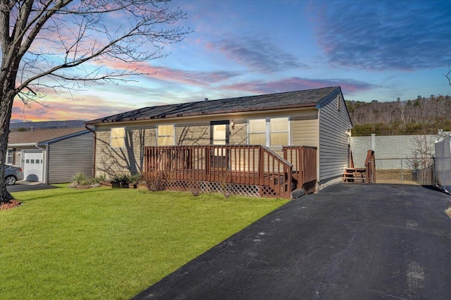 view of front of home featuring a lawn and a deck