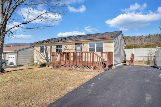 view of front of property featuring a wooden deck and a front yard