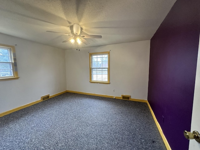 carpeted spare room featuring ceiling fan and a textured ceiling