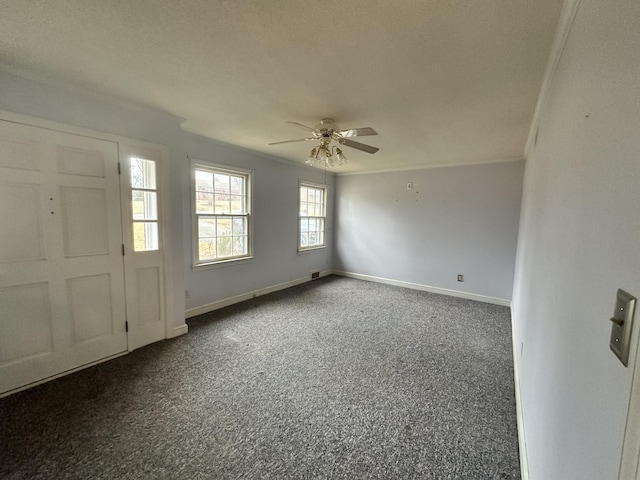 carpeted foyer entrance with ceiling fan and ornamental molding