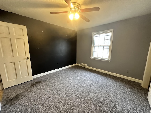 carpeted spare room featuring ceiling fan