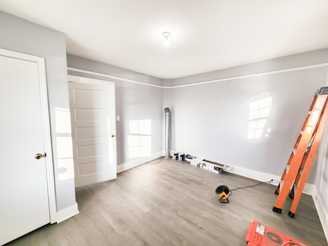 workout room with wood finished floors, a wealth of natural light, and baseboards