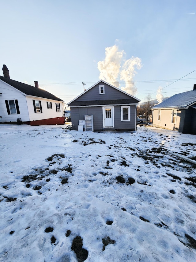 view of snow covered back of property