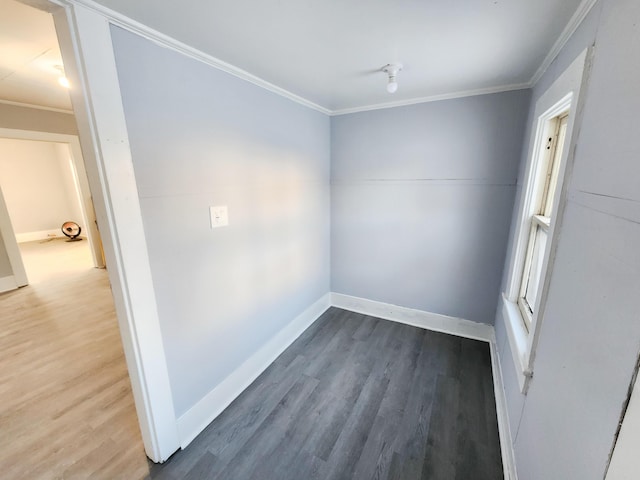 unfurnished room with baseboards, wood finished floors, and crown molding