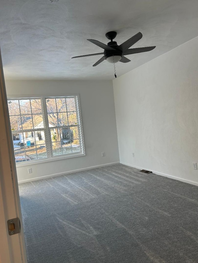 carpeted spare room with ceiling fan