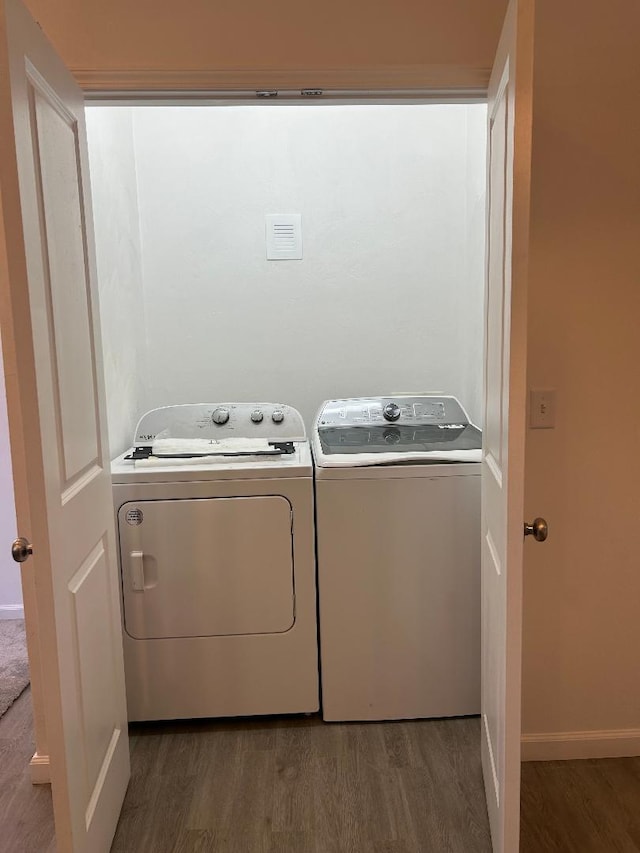 laundry room with washer and dryer and dark hardwood / wood-style floors