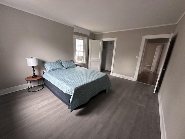 bedroom with a closet, dark hardwood / wood-style flooring, and crown molding