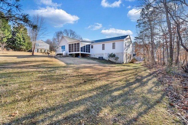 rear view of property featuring a sunroom and a yard