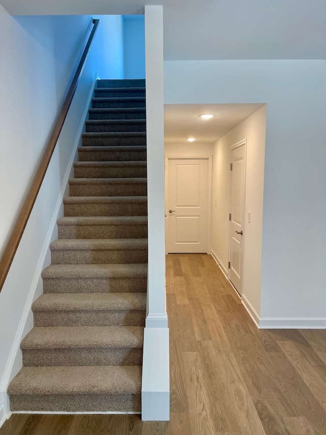 stairway with hardwood / wood-style flooring