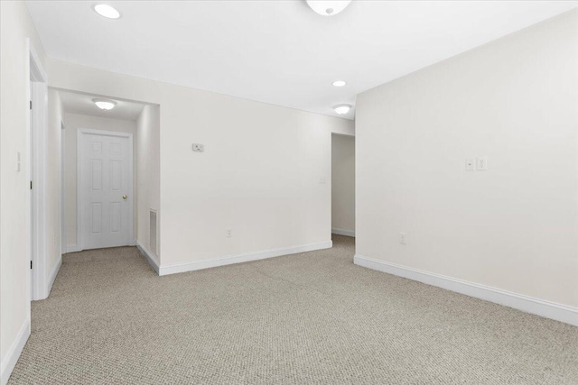 unfurnished room featuring light carpet