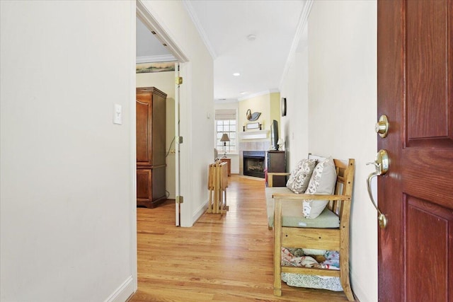 corridor featuring ornamental molding and light hardwood / wood-style floors