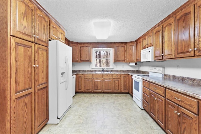 kitchen with sink, a textured ceiling, and white appliances