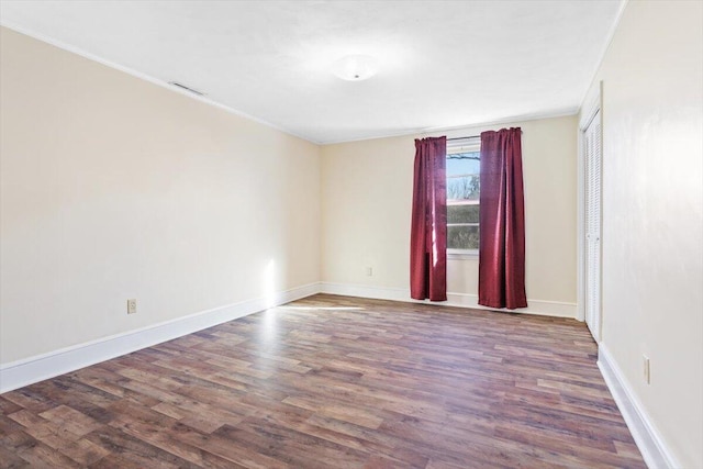 unfurnished room with ornamental molding and dark hardwood / wood-style floors