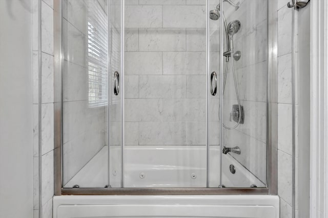 bathroom with shower / bath combination with glass door