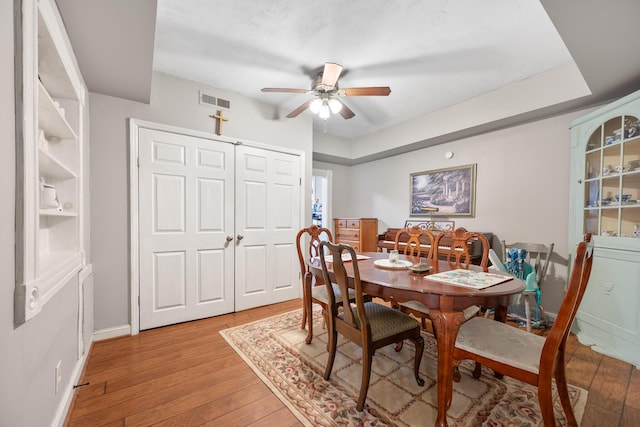 dining space with ceiling fan and light wood-type flooring