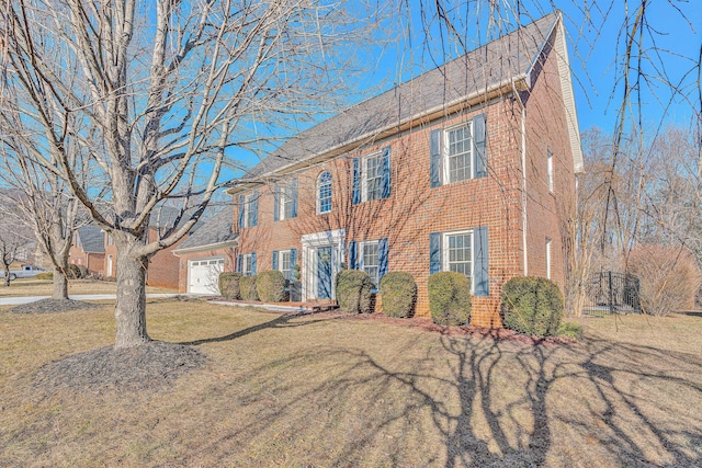 colonial home featuring a garage and a front yard