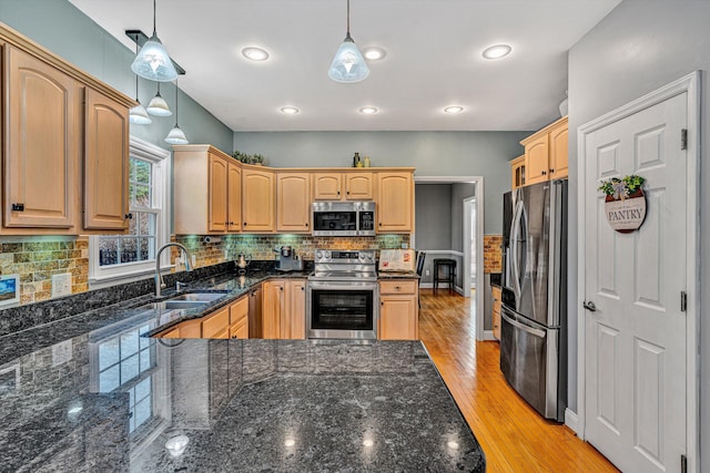 kitchen with sink, decorative light fixtures, appliances with stainless steel finishes, and light brown cabinets