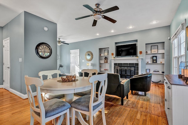 dining area featuring a fireplace, plenty of natural light, and built in shelves