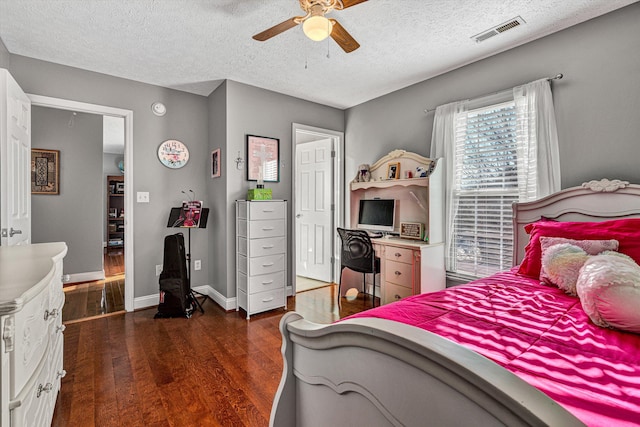 bedroom with a textured ceiling, dark hardwood / wood-style floors, and ceiling fan