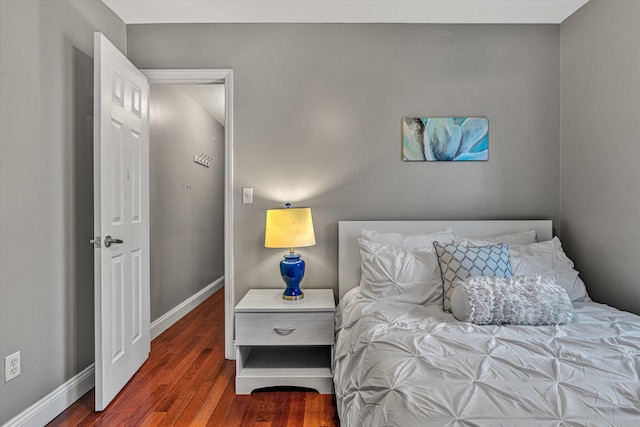 bedroom with dark hardwood / wood-style floors