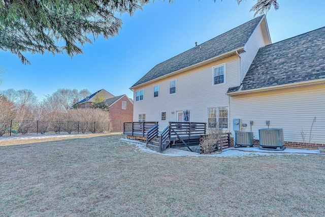 rear view of property featuring a wooden deck, a yard, and central air condition unit