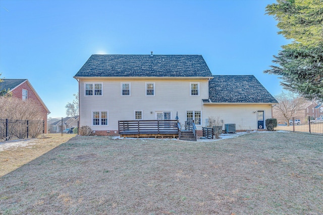 rear view of house featuring central AC unit and a lawn