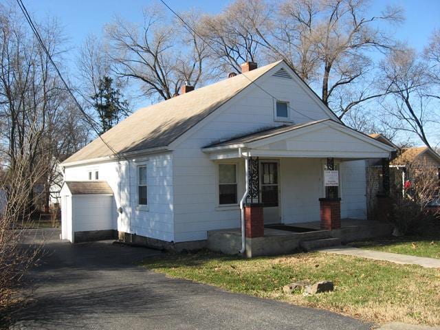 bungalow-style house with a garage, an outdoor structure, and a porch