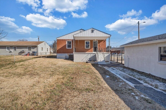 back of house featuring central air condition unit and a yard