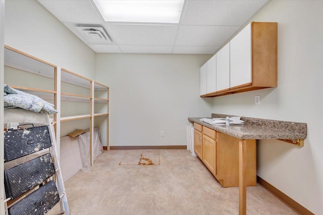 interior space featuring light carpet and a drop ceiling