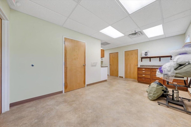 interior space with light carpet, a drop ceiling, and two closets