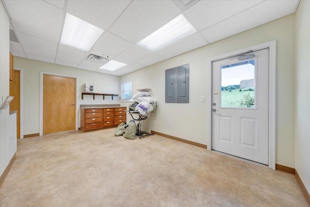 interior space featuring a drop ceiling, a wealth of natural light, and electric panel