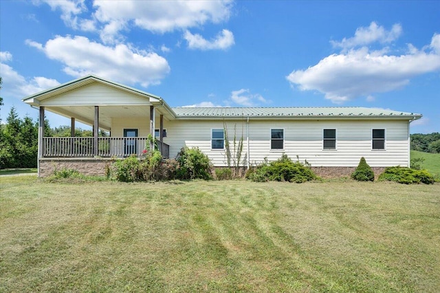 back of house with covered porch and a yard