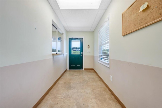 entryway featuring a paneled ceiling and light carpet