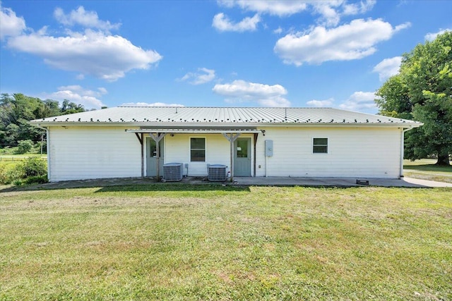 back of house with central AC, a patio area, and a yard