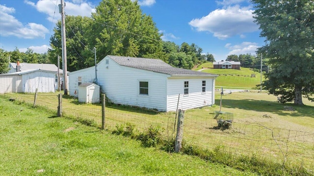 view of property exterior featuring a lawn and a shed