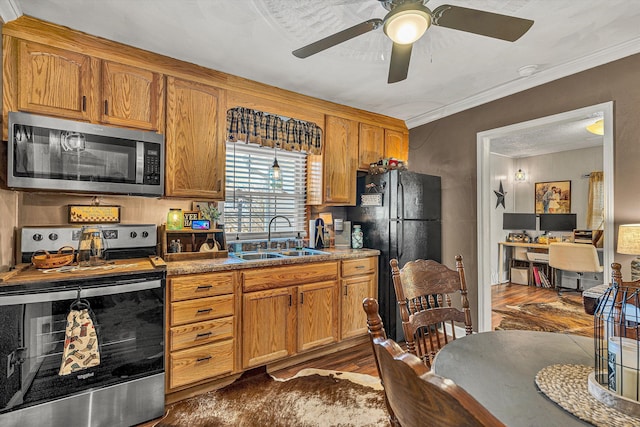 kitchen featuring sink, crown molding, ceiling fan, appliances with stainless steel finishes, and dark hardwood / wood-style flooring