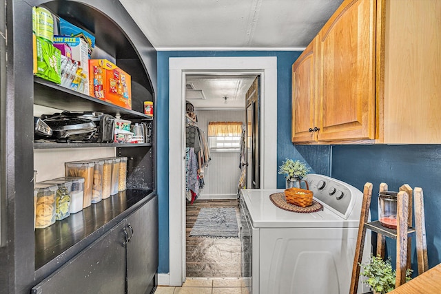 washroom featuring crown molding, cabinets, washer / dryer, and light tile patterned floors