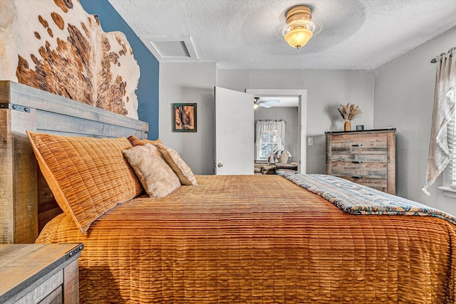 bedroom with ceiling fan and a textured ceiling