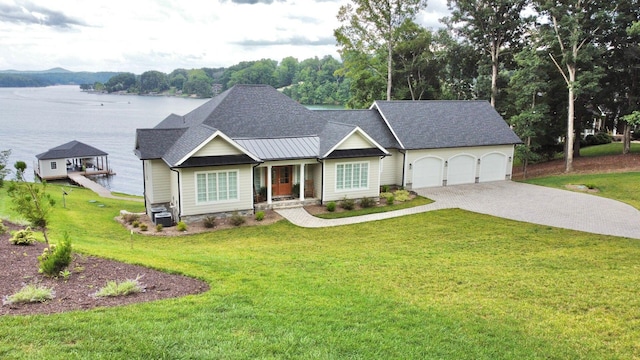 view of front of property with a garage, a water view, and a front yard