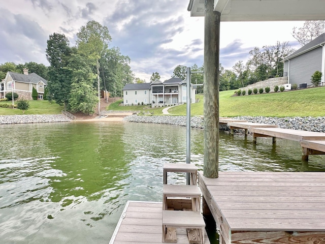 dock area with a lawn and a water view