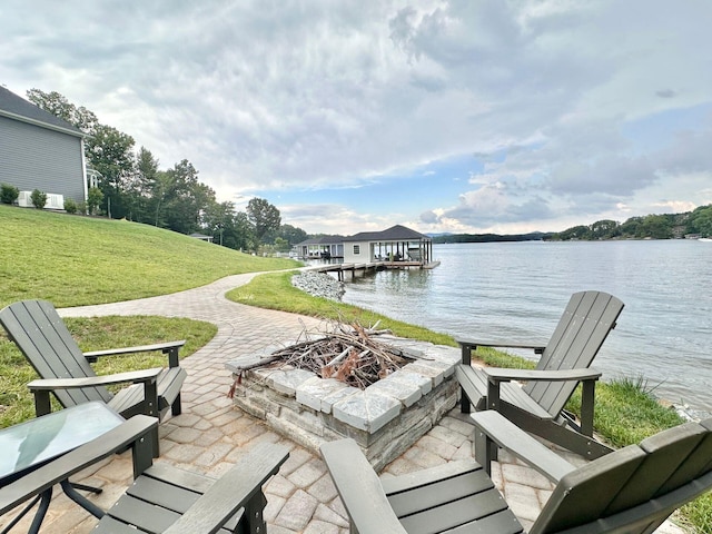 view of dock with a patio area, a yard, a fire pit, and a water view