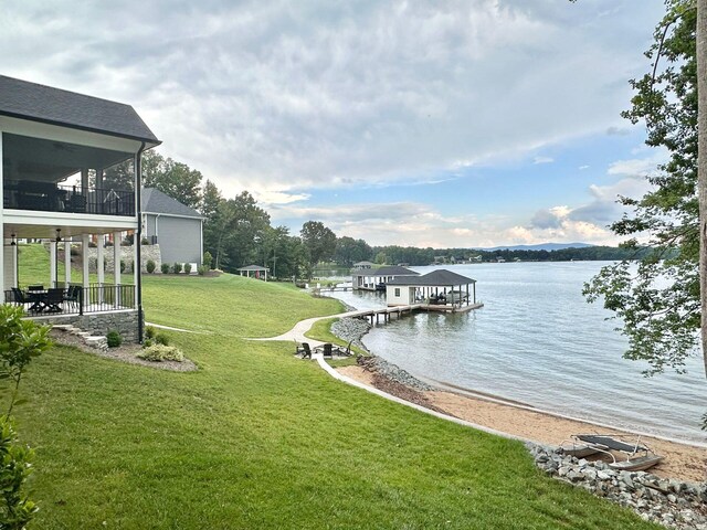view of dock featuring a water view and a yard