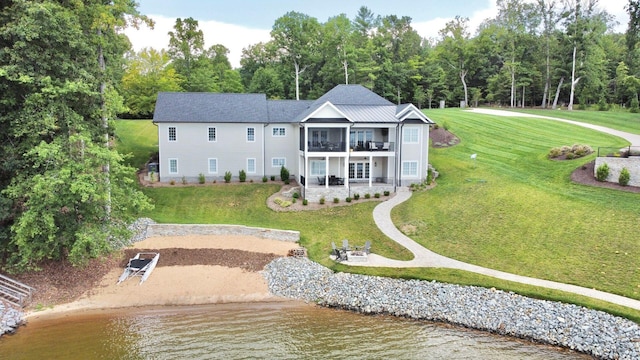 rear view of property with a balcony, a sunroom, and a water view