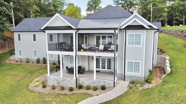back of property with french doors, a balcony, a lawn, and a patio area