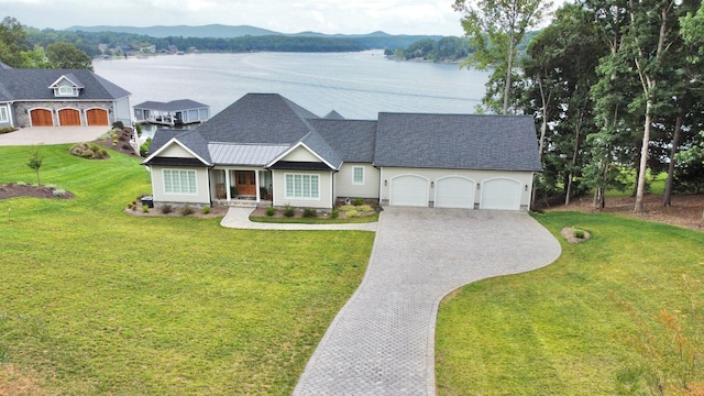 view of front of property featuring a garage, a water and mountain view, and a front yard