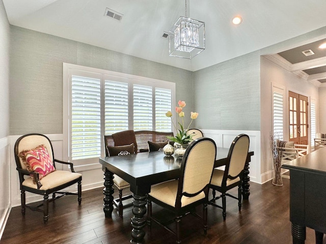 dining space featuring ornamental molding, an inviting chandelier, and dark wood-type flooring