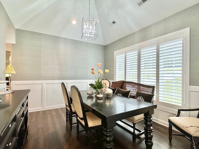 dining space featuring dark wood-type flooring, a chandelier, and vaulted ceiling