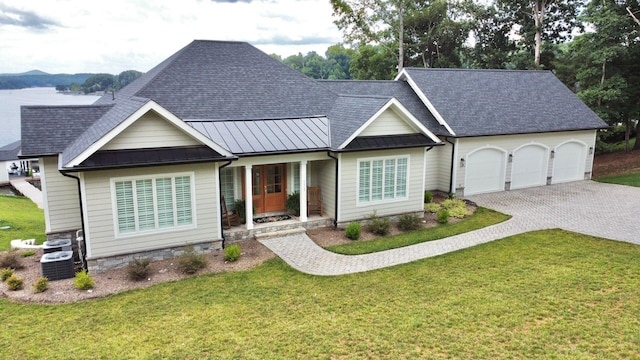 view of front of property featuring a front yard, central AC unit, and a garage